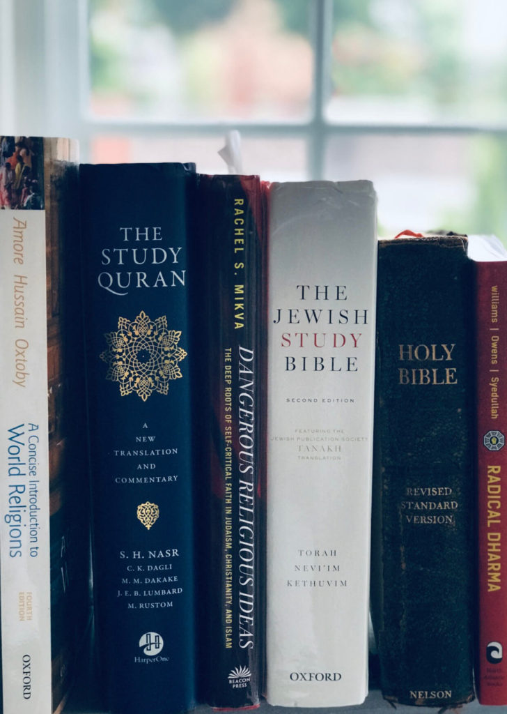 Photo of a collection of religious texts including the Bible, the Torah, and the Quran